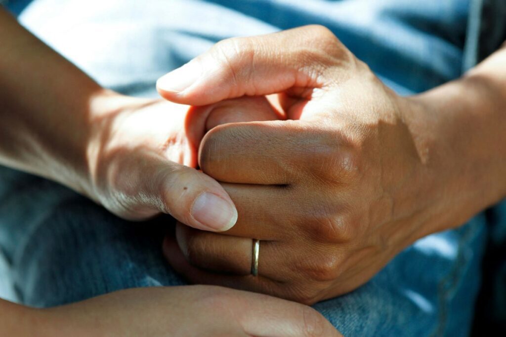 Hands holding on to each other, depicting the power of caregiving.