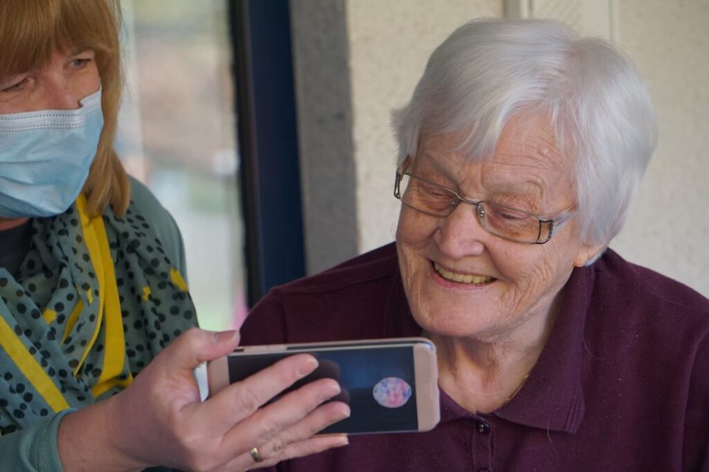 Elderly Woman Watching With Caregiver