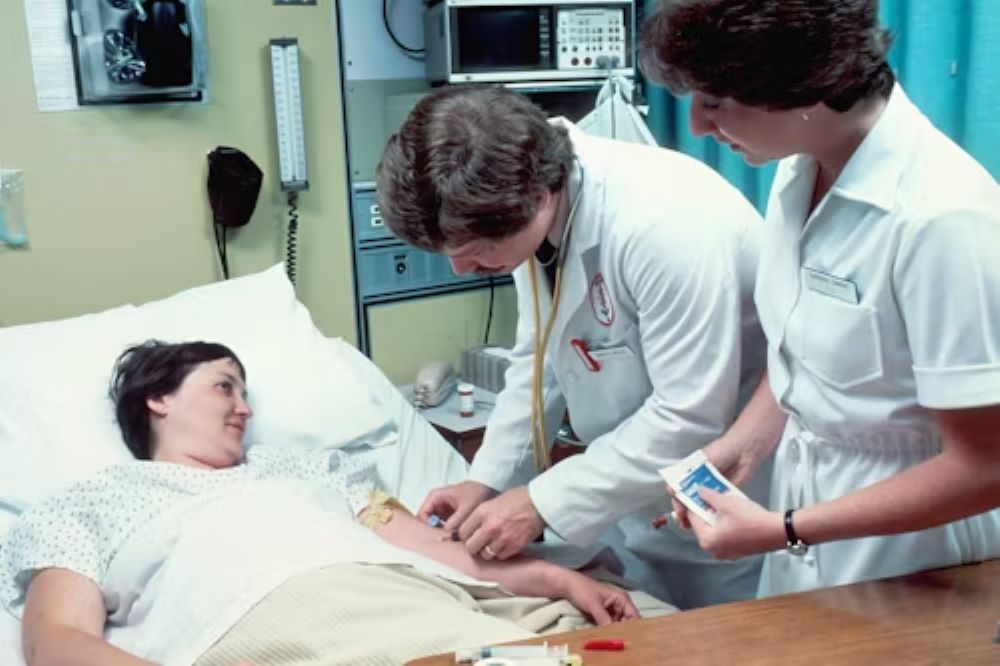 Two People Doing A Procedure On A Patient 