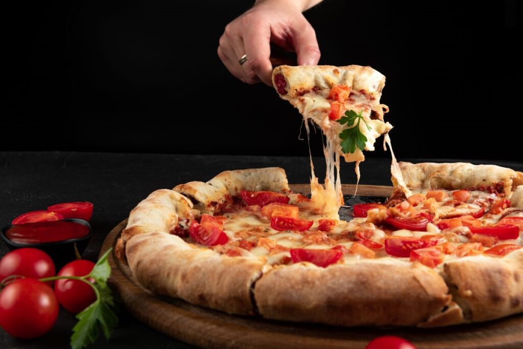 A person pulling out a slice of pizza.