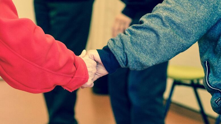Two people holding hands, depicting the beautiful journey of caregiving.