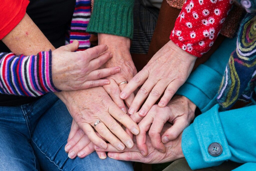 Group of hands stacked together symbolizing unity in support groups.