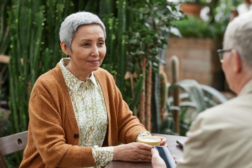 A wife smiling at his husband while drinking coffee.